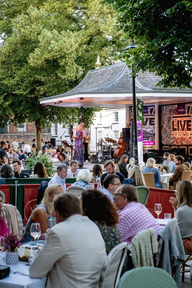 Vibrant summer evening crowds gathering on the historic Pantiles promenade outside Essence.