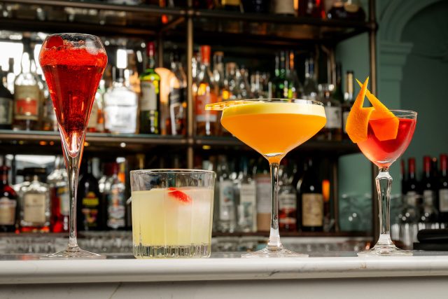 Four vibrant cocktails and mocktails on the marble bar at Essence in Kent.